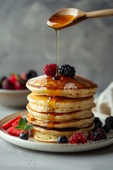 On a dark background, blueberry, raspberry, mint, and honey pancakes for breakfast.