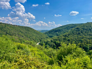 Picturesque view of green hills and valley under blue sky in Germany