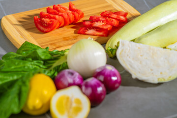 Fresh assortment of vegetables and ingredients placed on a cutting board, ready for cooking