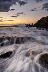 Sunset on Azkorri beach, Getxo, Bizkaia, with the silky sea between the rocks