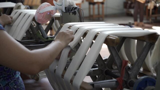 Silkworm cocoon thread factory. Worker hands are arranging threads.