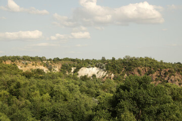 Big hill with green trees and sand