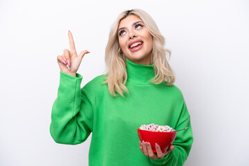 Young Russian woman holding a bowl of cereals isolated on white background pointing up a great idea