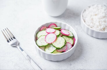 Cucumber and radish salad in a bowl with rice