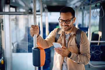 Happy public transport passenger using smart phone during ride.