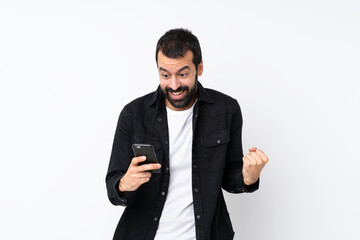 Young man with beard over isolated white background surprised and sending a message