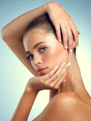 Naklejka premium Studio, pose and portrait of woman for skincare, healthy skin and wellness for transformation with pride. Girl, benefits and results with cosmetics for beauty treatment, serious and blue background