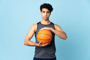 Obraz premium Young Venezuelan man isolated on blue background playing basketball