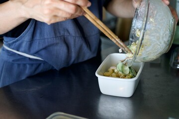 作ったマカロニサラダを保存容器に入れているところ