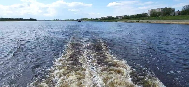 Swirling blue waves astern of a moving ship