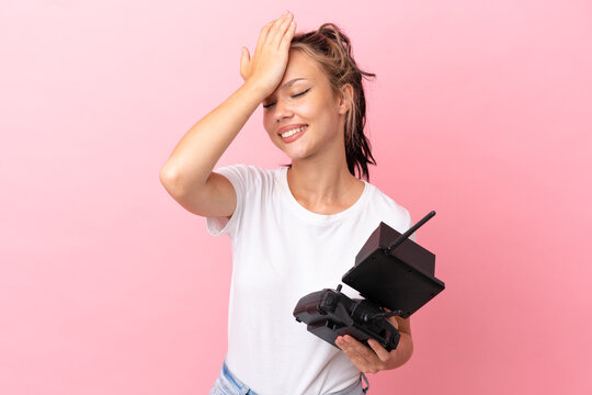 Teenager Russian girl holding a drone remote control isolated on pink background has realized something and intending the solution