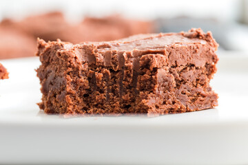 Close-up of a rich, moist brownie slice on a white plate