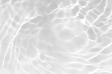 White water with ripples on the surface. Defocus blurred transparent white colored clear calm water surface texture with splashes and bubbles. Water waves with shining pattern texture background.