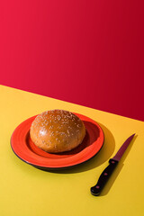 A hamburger bun and a knife. Copy space.