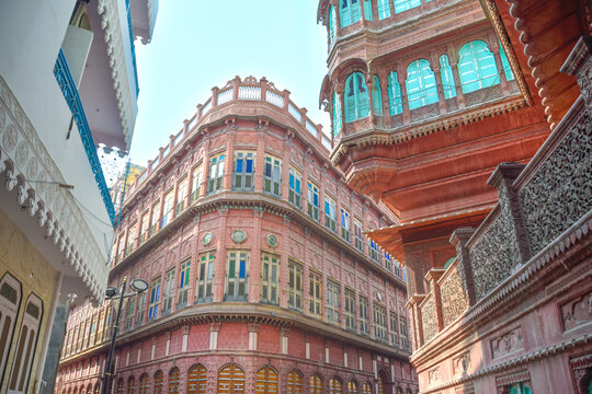 Dulmera Havelis in Bikaner with windows in green tones and touristy red facades