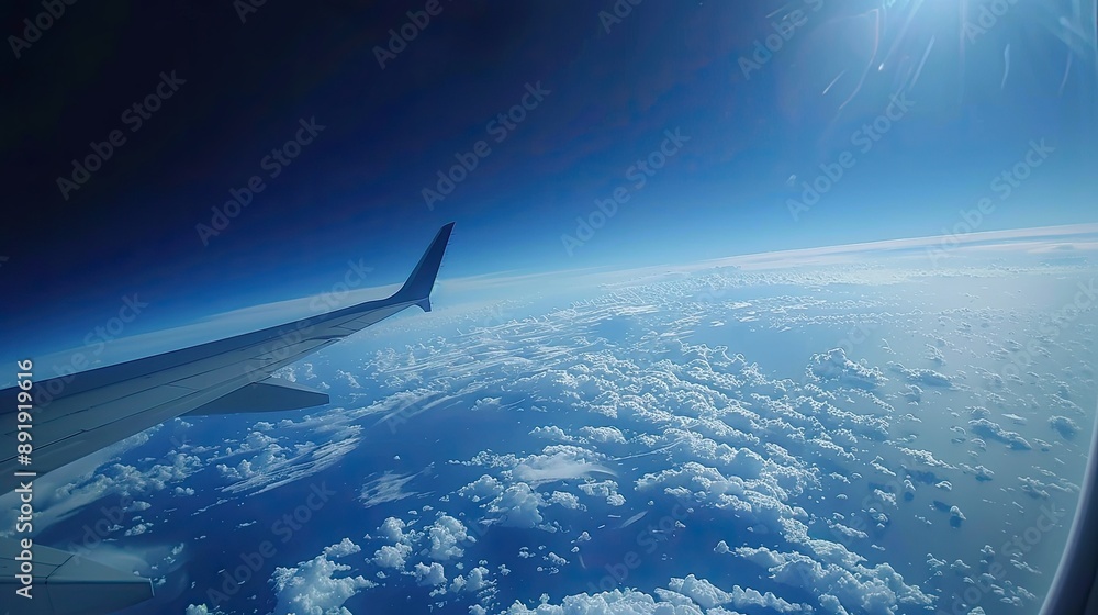 Poster high-altitude view from a plane with wing, clouds, and earth's curvature visible through the window