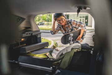 mature blonde woman travel take stuff belongings from the back of car