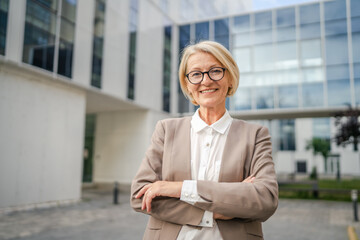 Portrait of one caucasian blonde mature businesswoman stand outdoor
