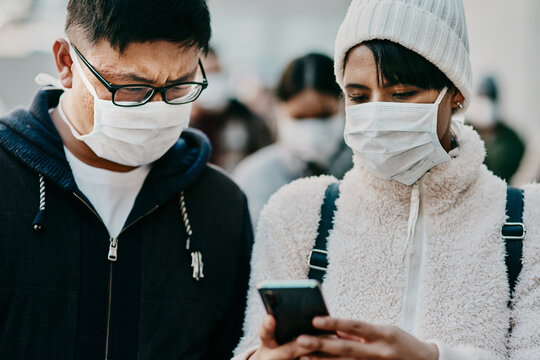 People, outside and face mask with smartphone in city, news and covid or new variant update on app. Social media, awareness notification and couple online, public safety and message on pandemic blog