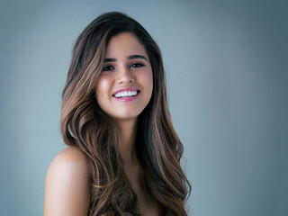 Hair care, portrait and woman in studio with salon, collagen and volume treatment for beauty. Smile, confident and female person with brunette, long and shiny hairstyle by gray background with mockup