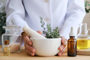 Natural medicine or herbal remedy for alternative treatment. Pestel and mortar with natural oil and herb.