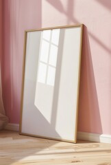 A large white framed mirror sits on a wooden floor in a room with a pink wall