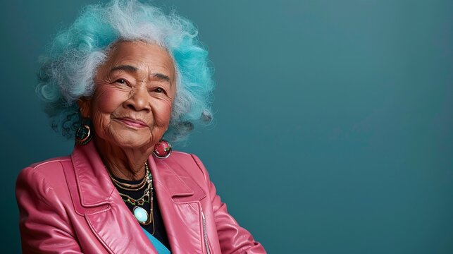 Elderly individual with vibrant hair and a pink leather suit posing joyfully with colorful accessories Stock Photo with copy space