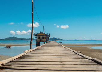 Fototapeta premium Rustic wooden pier leading to seaside hut on a sunny day