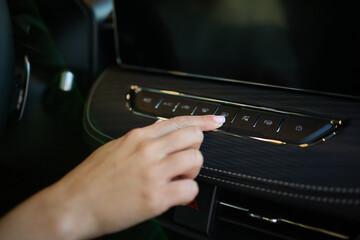 Expert is operating the control panel of a luxury vehicle with advanced technology and sleek design