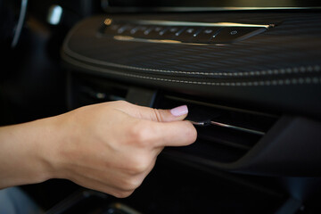 Expert is operating the control panel of a luxury vehicle with advanced technology and sleek design