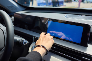 Expert is operating the control panel of a luxury vehicle with advanced technology and sleek design