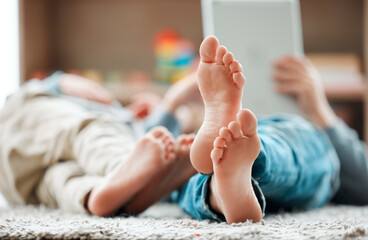 Closeup, barefoot and kids with tablet, home and typing with entertainment, social media and connection. Friends, apartment and children on carpet, technology and internet with digital app for game