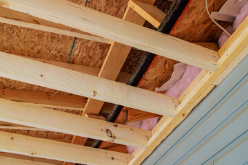 Process of building new home involves framing of roof trusses with wood frame beams