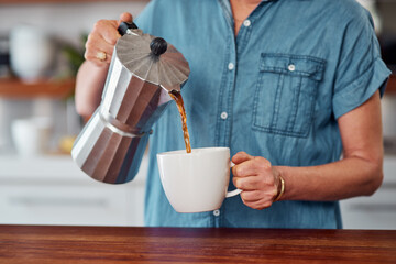 Woman, hands and coffee with moka pot for morning, caffeine or breakfast beverage in mug at home. Closeup of female person pouring latte, cappuccino or espresso for drink, energy or liquid in kitchen