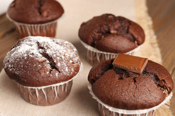 Tasty chocolate cupcakes on wooden background, closeup