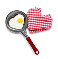 Frying pan with heart-shaped fried egg and napkin on white background