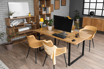 Interior of stylish office with workplace, shelf units and plants
