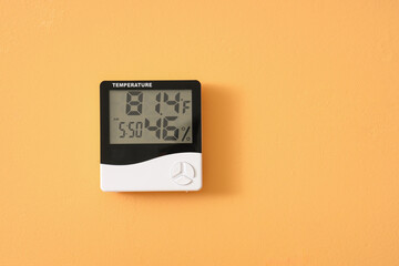 Digital hygrometer on orange wall