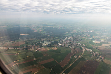 Obraz premium View through the window of aircraft flying early in the morning over the suburbs of Prague in the Czech Republic