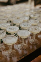 Close-up view of several champagne glasses filled with bubbly champagne on a wooden table