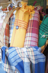 A storage basket made of wood filled with an assortment of towels