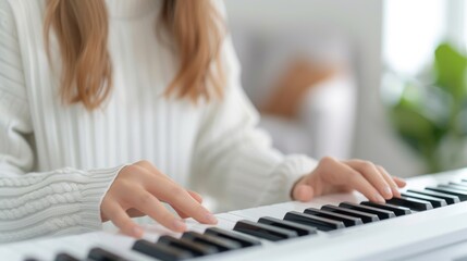 Fototapeta premium Young woman sitting and playing keyboard, free time, hobbies and playing music.