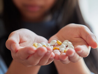 家にいる子供がたくさんの薬の錠剤を持つ様子