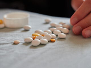 たくさんの各種類の薬品の錠剤の様子と子供の手