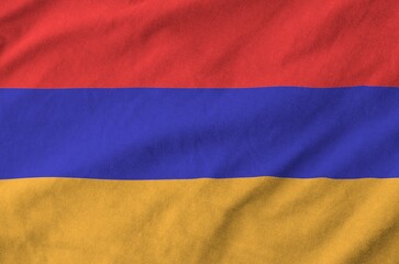 Armenia flag depicted on folded wavy fabric of old cloth close up