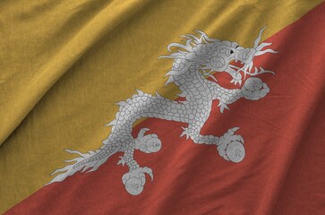 Bhutan flag depicted on folded wavy fabric of old cloth close up