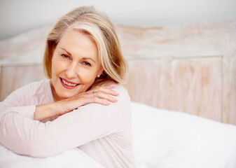 Senior woman, portrait and relax in bed with mindfulness, happy retirement and weekend in home. Elderly female person, smile and wake up on mattress for morning peace, wellness and pyjama clothes