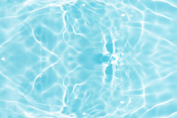 Blue water with ripples on the surface. Defocus blurred transparent blue colored clear calm water surface texture with splashes and bubbles. Water waves with shining pattern texture background.