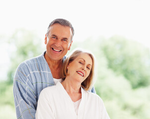 Fototapeta premium Portrait, love and window with mature couple, hug and support in living room of house together. Smile, face and trust with happy, senior man and woman bonding while enjoying retirement at home