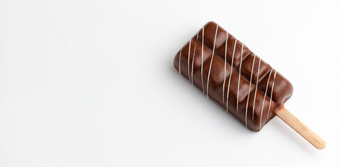 Chocolate ice cream bar with drizzle on a wooden stick, isolated on a white background. Cheesecake popsicle. Wide banner with copy space, top view.